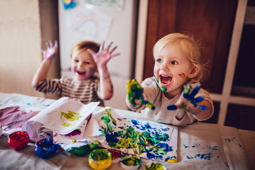 دو کودک با خوشحالی در حال رنگ بازی