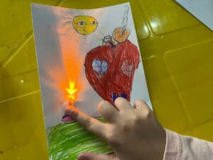 کودک در نقاشی اش چراغ قوه هم قرار داده